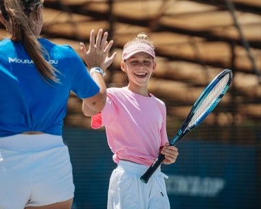 coach mouratoglou tape dans les mains d'une jeune fille en stage