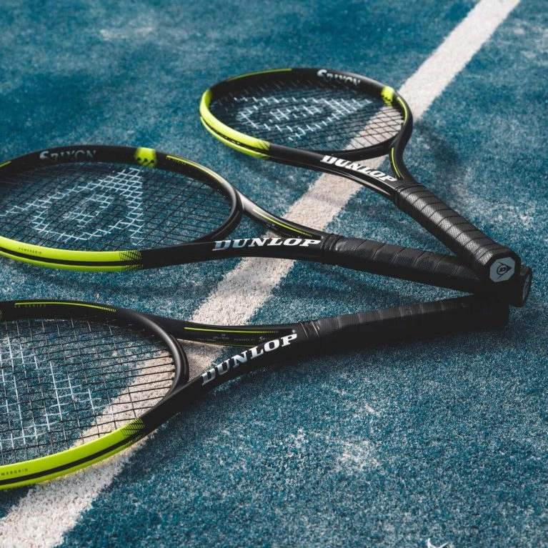 3 raquettes dunlop posées sur un court de tennis