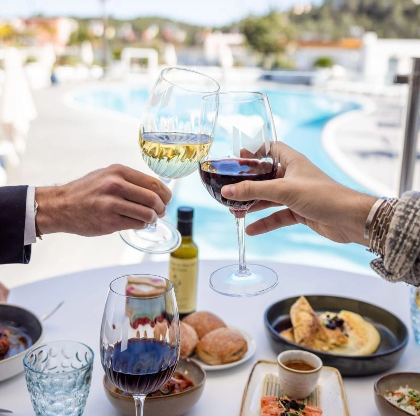 2 personnes qui trinquent au bord de la piscines du restaurant l'emblème